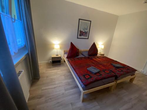 um quarto com uma cama com almofadas vermelhas em 80 m² neues vier Zimmer Apartment 