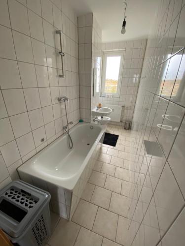 uma casa de banho branca com uma banheira e um lavatório em 80 m² neues vier Zimmer Apartment 