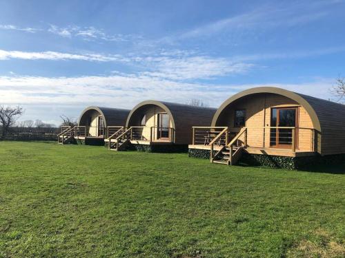 a group of three domed houses in a field at Eco-friendly Cabins Cabin 1 in Norton Disney