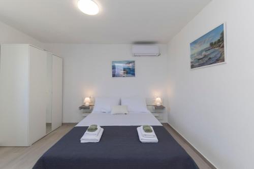 um quarto branco com uma cama com duas toalhas em Holiday House Beram em Zadar