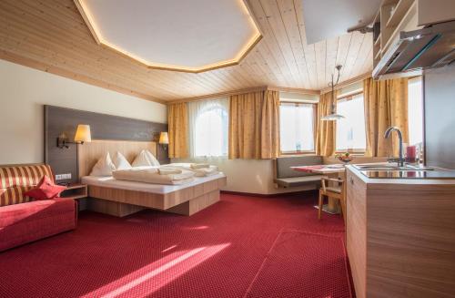 a hotel room with a bed and a kitchen at Harmls Aparthotel in Flachau
