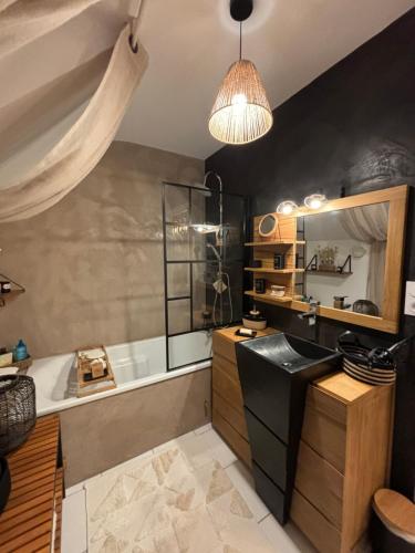 une salle de bain avec une baignoire et un lavabo dans l'établissement Saint Armel : Maison arborée près du Golfe, à Saint-Armel
