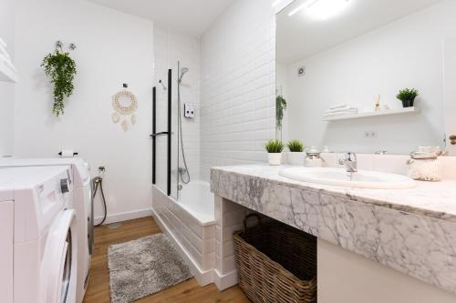 biała łazienka z umywalką i prysznicem w obiekcie Casa Ohana w mieście Fuengirola