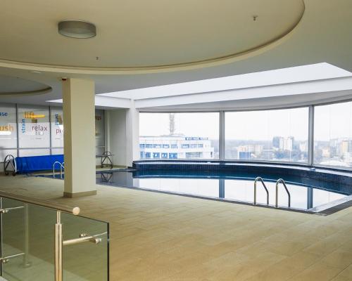 een zwembad in een gebouw met een groot raam bij Capital M - Bednbeyond, Westlands Nairobi, Kenya-Call 25472I95O319 in Nairobi