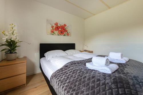 a bedroom with a large bed with towels on it at 75, Relax - Nature - Cycling - Hiking - Central! - Leisure only in Oisterwijk