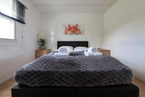 a bedroom with a large bed in a white room at 75, Relax - Nature - Cycling - Hiking - Central! - Leisure only in Oisterwijk