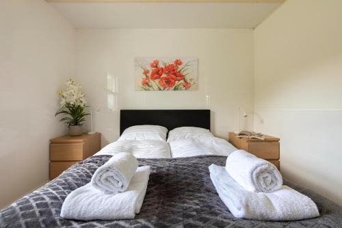 a bedroom with a bed with two white towels on it at 75, Relax - Nature - Cycling - Hiking - Central! - Leisure only in Oisterwijk