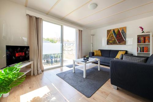 a living room with a couch and a table at 75, Relax - Nature - Cycling - Hiking - Central! - Leisure only in Oisterwijk
