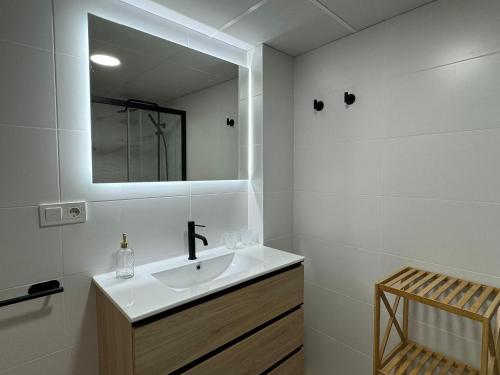 a white bathroom with a sink and a mirror at Apartamento Las Teresas Khalifa in Córdoba