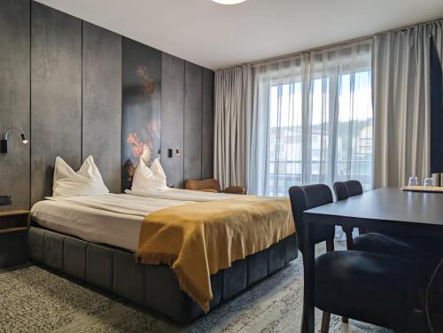 una habitación de hotel con una cama grande y una mesa en Vila Topaz, en Băile Felix
