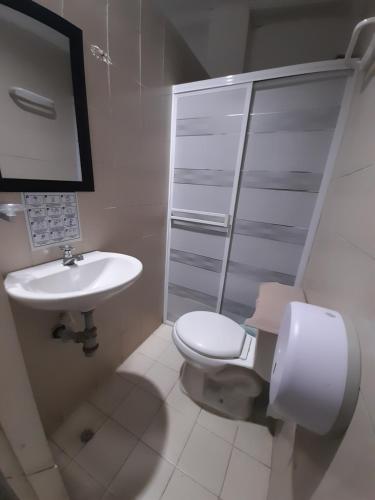 uma casa de banho branca com um WC e um lavatório em Rivera Hostel em Santa Marta