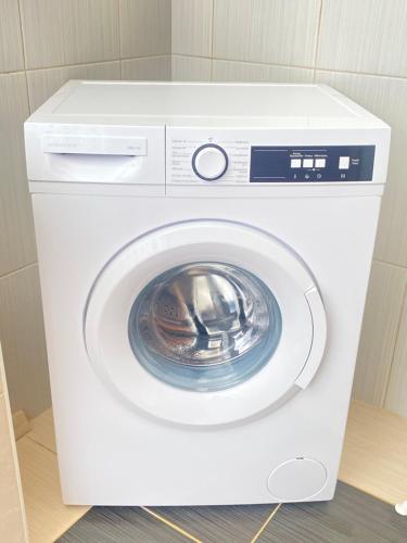 a white washing machine sitting in a room at Nikis Home in Rethymno