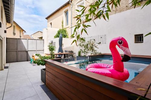 un flotteur de flamants roses dans une piscine dans l'établissement Maison de ville moderne climatisée avec piscine, à Morières-lès-Avignon