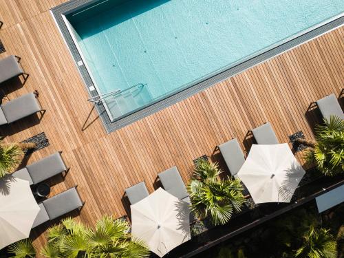 una vista sul soffitto di una piscina con sedie e ombrelloni di Hotel Kassian a Lagundo