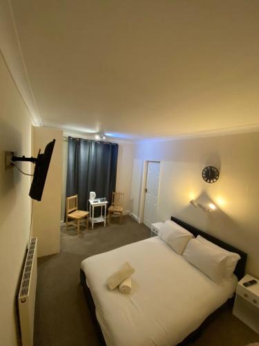 a bedroom with a large white bed and a table at Sea Side Hotel in Skegness