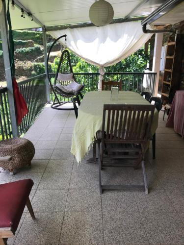 a screened porch with a table and a swing at O refugio do Mineiro in Arouca