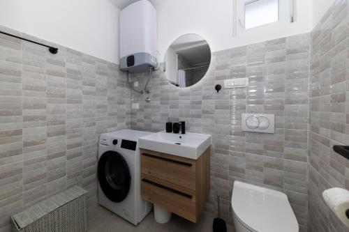 uma casa de banho com uma máquina de lavar roupa e um lavatório em Holiday House Beram em Zadar