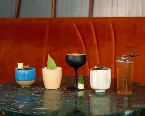 a table with four cups and a wine glass at DoubleTree by Hilton Hotel London - Tower of London in London