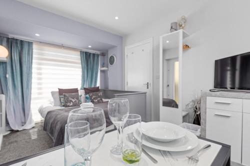 a kitchen and living room with wine glasses on a table at Rottingdean Boutique Studio Apartment By The Sea in Rottingdean