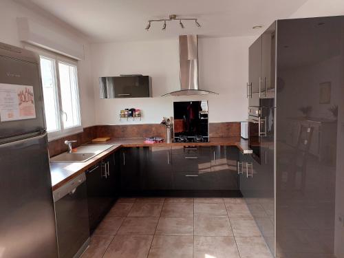 une cuisine avec un évier et un réfrigérateur dans l'établissement MONTALIEU SEJOUR Maison Les Lys, à Montalieu-Vercieu