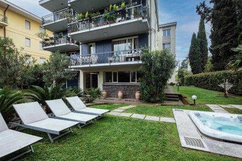 an apartment building with a patio and a swimming pool at Catullo 18 Apartment, Garda Lake, Jacuzzi, Fitness, Ac in Desenzano del Garda