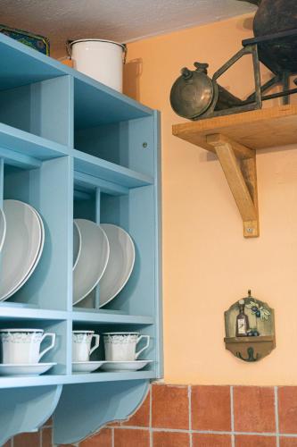 a blue cabinet with plates and cups on it at ΑΝeΜΙ in Anemótia