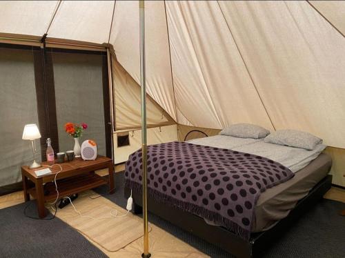 a bedroom with a canopy bed and a wooden table at Godaland Glamping in Hvolsvöllur