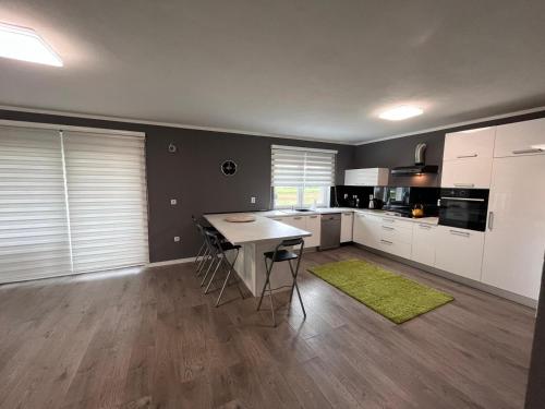 a kitchen with white cabinets and a green rug at Urban villa in Sarajevo