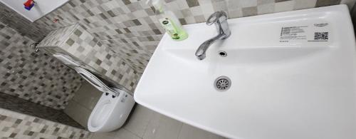een badkamer met een witte wastafel en een toilet bij Urban villa in Sarajevo