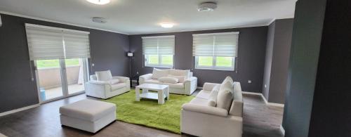 a living room with white furniture and a green rug at Urban villa in Sarajevo