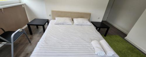 a bed with white sheets and pillows in a room at Urban villa in Sarajevo