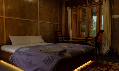 a bedroom with a bed with a purple blanket at Tsejor Homestay in Dirang Dzong