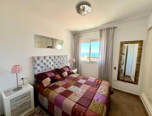 1 dormitorio con 1 cama y vistas al océano en Beachfront Penthouse Apartment with Large Terrace and Breathtaking Sea Views close to Marbella Spain, en Mijas Costa