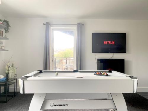 a pool table in a living room with a tv at Luxury Apartment with Balcony in Dewsbury