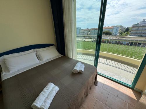 a bedroom with a bed and a large window at Bellariva appartamenti in Rimini