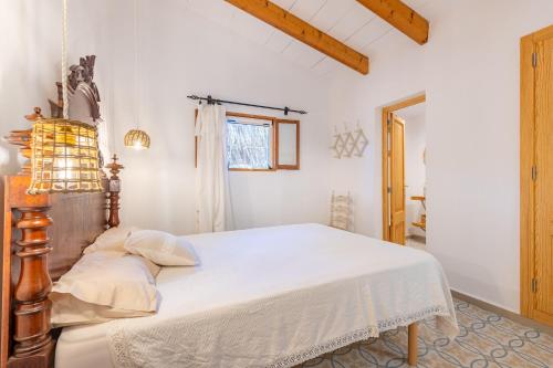 una camera da letto con un letto con lenzuola bianche e una finestra di Marina Ses Covetes a Campos