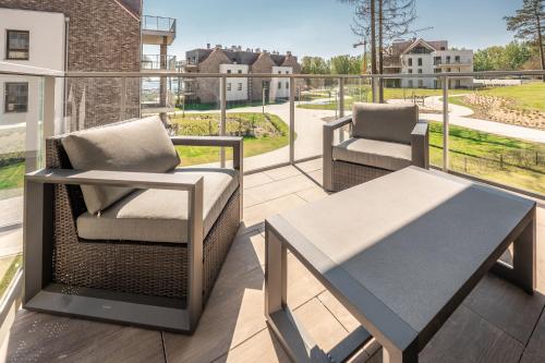 a patio with two chairs and a table on a balcony at Nautica Resort in Giżycko