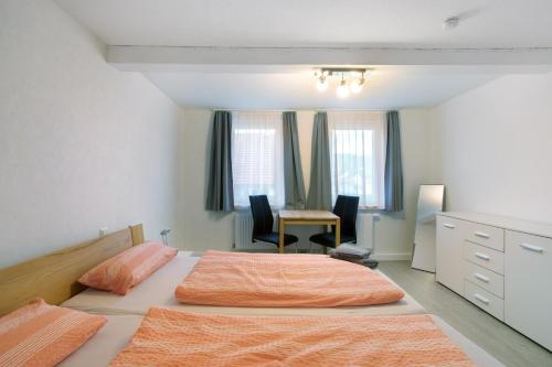 een slaapkamer met 2 bedden en een bureau. bij Ferienhaus Doris in Bad Urach
