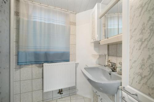 a white bathroom with a sink and a mirror at Ferienhaus Doris in Bad Urach