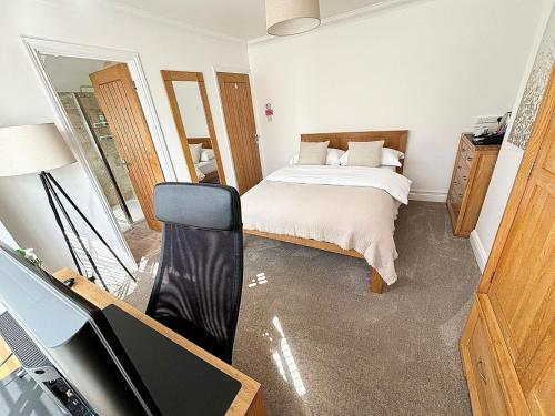 a bedroom with a bed and a dresser and a television at Carolines rooms in Cherry Hinton