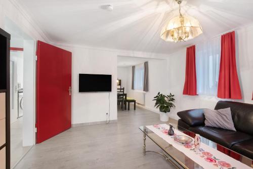 a living room with a black couch and a red door at Ferienhaus Doris in Bad Urach