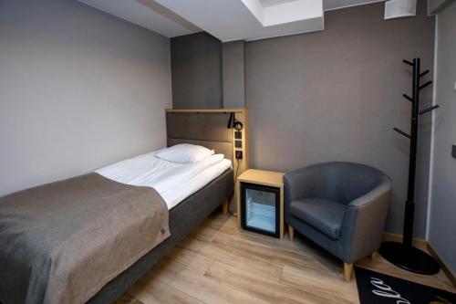 1 dormitorio pequeño con 1 cama y 1 silla en HOSTEL TOIVOLA, en Kemi