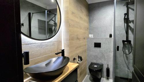 a bathroom with a sink and a mirror at Apartament Bursztynowy Jantar by TriApart in Jantar
