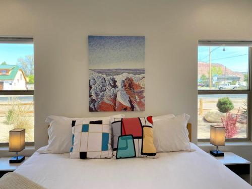 ein Schlafzimmer mit einem Bett mit zwei Lampen und einem Gemälde in der Unterkunft Timber & Tin E 2Bed 2Bath w Pool & Rooftop Deck in Kanab
