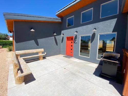 a building with a bench and a red door at Timber & Tin G 2Bed 2Bath w Pool & Rooftop Deck in Kanab