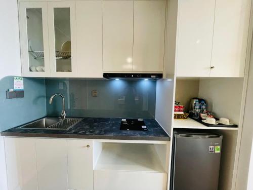 a kitchen with white cabinets and a sink at FLAMING0 Ibiza Hải Tiến Resort in Thanh Hóa