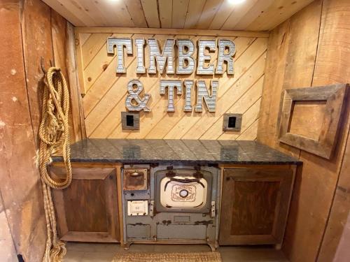 an entrance to aimlerin sign on a wooden wall at Timber & Tin H 2Bed 2Bath w Pool & Rooftop Deck in Kanab
