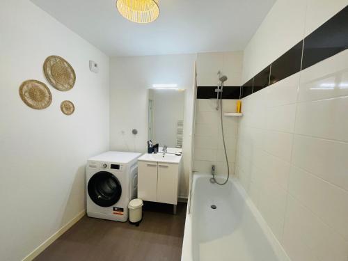 La salle de bains est pourvue d'un lave-linge et d'un lave-linge. dans l'établissement Appartement 2 chambres Lille - proche du métro, à Lille