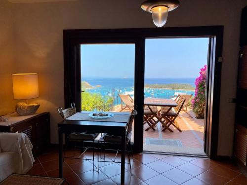 a living room with a door open to a patio at Villaggio Est a Capo Coda Cavallo San Teodoro in San Teodoro