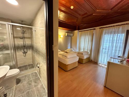 a bathroom with a shower and a bedroom with a sink at Adil Konak Hotel in Istanbul